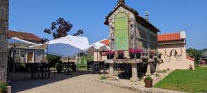 a building with an umbrella and tables and chairs at Pensión Ponte das Febres in Tui