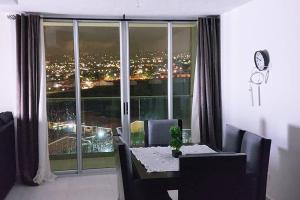 a dining room table with a view of a city at Altamira Cozy apartment with amazing views in Santo Domingo