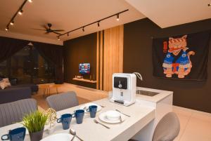 Il dispose d'une cuisine et d'un salon avec une table et une télévision. dans l'établissement Midvalley Southkey Mosaic Suite by Nest Home, à Johor Bahru