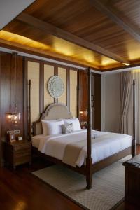 a bedroom with a large bed with a wooden ceiling at Plataran Bromo in Ngadiwano