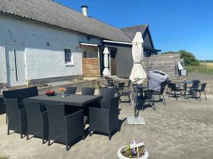 a patio with tables and chairs and an umbrella at Smultronstallet Gårdshotell in Valleberga