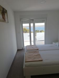 a bedroom with two beds and a view of the ocean at Apartmani Deluxe in Jasenice
