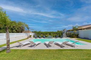 basen z leżakami i basen w obiekcie Villa White Luxury Residence w mieście Marsala