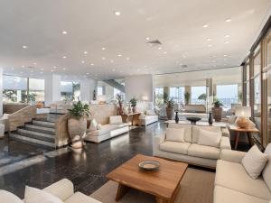 a large living room with white furniture and windows at Leptos Panorama Hotel in Kalamaki
