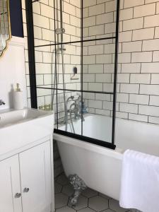 Baño blanco con bañera y lavamanos en SEAFRONT SANCTUARY Beautiful Art Deco Apartment with Stunning City & Sea Views en Brighton & Hove