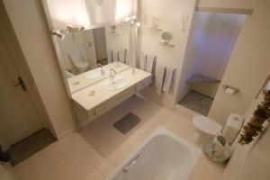 La salle de bains est pourvue d'un lavabo, de toilettes et d'un miroir. dans l'établissement Au Bel Air, à Clermont-Pouyguilles