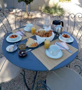 une table bleue avec de la nourriture pour le petit-déjeuner dans l'établissement Au Bel Air, à Clermont-Pouyguilles