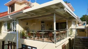 Casa con balcón con sillas. en Sundown Manor Guest House en Ciudad del Cabo