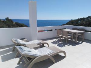 um pátio com cadeiras e uma mesa e o oceano em Mikro Nisi Studios em Agios Nikolaos