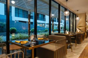 restauracja ze stołami i krzesłami oraz dużymi oknami w obiekcie Wekata Luxury w mieście Kata Beach