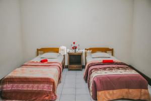 dos camas sentadas una al lado de la otra en una habitación en Villa Mawar Adinda Kuningan Syariah RedPartner, 
