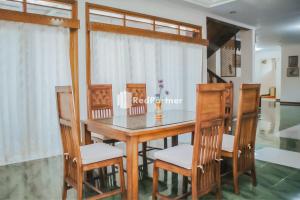 comedor con mesa de madera y sillas en Villa Mawar Adinda Kuningan Syariah RedPartner, 