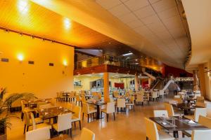 a restaurant with tables and chairs and a yellow wall at Heliconia Park Port Harcourt Hotel and Suites in Port Harcourt
