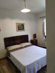 1 dormitorio con 1 cama grande con manta blanca en Foresteria del Re, en Montelupone
