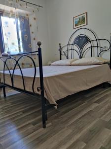 a bedroom with a black bed with a wooden floor at Foresteria del Re in Montelupone