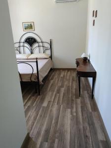 sypialnia z łóżkiem i drewnianą podłogą w obiekcie Foresteria del Re w mieście Montelupone