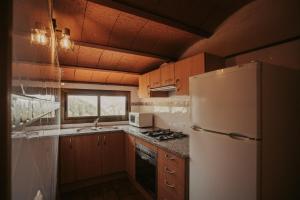 a kitchen with a white refrigerator and a sink at Subirana Rural in Les Llosses