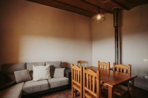 a living room with a couch and a table and chairs at Subirana Rural in Les Llosses +5 photos