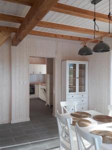 a kitchen and dining room with a table and chairs at Domek Kajakarza in Borsk