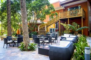 a patio with tables and chairs in front of a building at Hotel Royal Oasis in Port-au-Prince