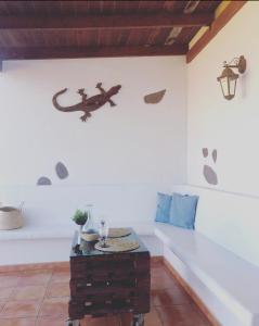 una habitación con una mesa y un lagarto en la pared en Balcón del amanecer fuerteventura en El Charco