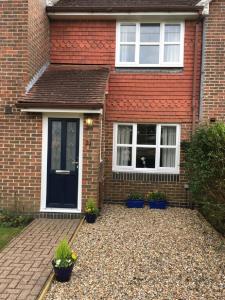 una casa de ladrillo rojo con una puerta negra en KB21 Attractive 2 Bed House, pets/long stays with easy links to London, Brighton and Gatwick, en Roffey