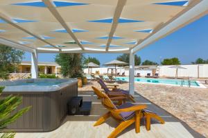 patio con vasca idromassaggio e sedie sotto un baldacchino di Villa Artesole by BarbarHouse a Oria