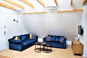 een woonkamer met twee blauwe banken en een tafel bij Apartamenty Royal Maris 4 - najlepsza lokalizacja w Ustce, blisko plaży i portu, bezpłatny parking, ścicsłe centrum in Ustka