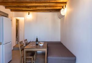 a dining room with a table and a white refrigerator at Aelia House Serifos in Serifos Chora