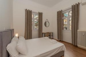 sypialnia z białym łóżkiem i 2 oknami w obiekcie Charming 3bd apt. close to metro w Atenach
