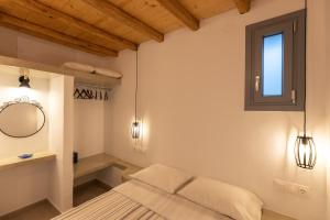 a bedroom with a bed and a mirror and lights at Aelia House Serifos in Serifos Chora