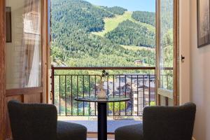 d'un balcon avec une table et deux chaises et une vue. dans l'établissement Serras Andorra, à Soldeu