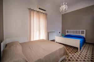 a bedroom with a bed and a chandelier at The House In The Bay in Castellammare del Golfo