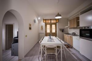 a kitchen with a white table and chairs in a room at The House In The Bay in Castellammare del Golfo