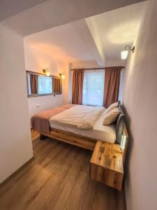 ein Schlafzimmer mit einem großen Bett und einem Holztisch in der Unterkunft Family Apartment in Sighişoara