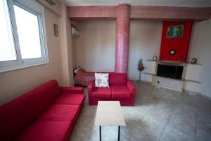a living room with a red couch and a table at House in Eleusis (Elefsina) a city close to Athens in Elefsina