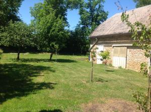 ein Garten mit zwei Bäumen vor einem Gebäude in der Unterkunft Gite de Manon in Bozouls