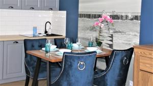 Una cocina con una mesa con sillas y un fregadero. en Apartamenty Royal Maris 1 - najlepsza lokalizacja w Ustce, blisko plaży i portu, bezpłatny parking, ścisłe centrum, en Ustka