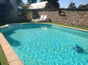 ein großer Swimmingpool mit blauem Wasser in einem Hof in der Unterkunft Gite de Manon in Bozouls