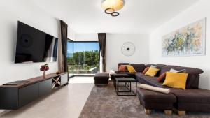 a living room with a couch and a tv at Villa Faloniga by Villas Holiday in Vranje Selo