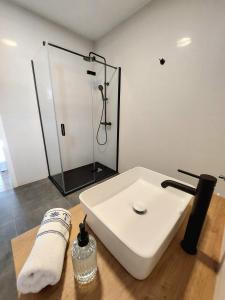 W łazience znajduje się biała umywalka i prysznic. w obiekcie Luxury Sea View Apartment w mieście Jesenice
