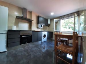 a kitchen with a table and a dining room at Lo de Jaime in Arriondas