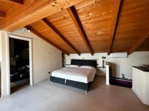a bedroom with a bed and a wooden ceiling at Residenza a schiera vista lago Feriolo in Feriolo