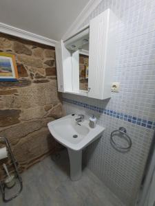 a bathroom with a white sink and a mirror at A Palleira de Aguil in Castro Caldelas
