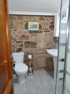 een stenen badkamer met een toilet en een wastafel bij A Palleira de Aguil in Castro Caldelas