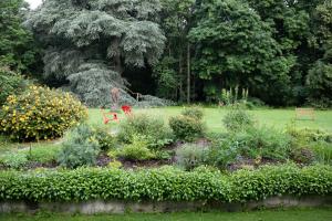 Bed & Breakfast - La closerie de la Fuye في Ballan-Miré: حديقة بها زهور ونباتات في حديقة
