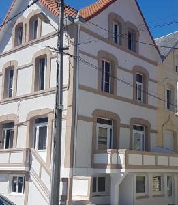 un grande edificio bianco con molte finestre di L'Orphie - 50m plage - confort - Baignoire a Berck-sur-Mer Altre 6 foto