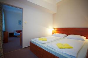 Un dormitorio con una cama con toallas amarillas. en Wellness Hotel Central, en Klatovy