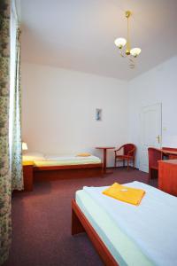 a room with a bed and a table and chairs at Wellness Hotel Central in Klatovy