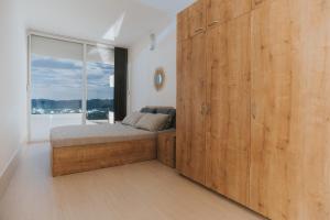 een slaapkamer met een bed en een grote houten kast bij Panorama Apartments in Gevgelija